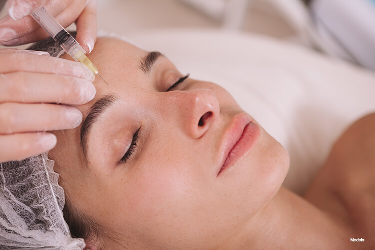 A woman getting an injection on her forehead